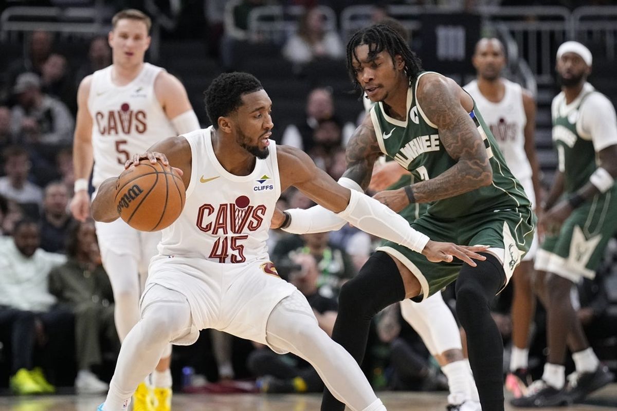 Mar 17, 2026; Milwaukee, Wisconsin, USA; Cleveland Cavaliers guard Donovan Mitchell (45) drives against Milwaukee Bucks guard/forward Kevin Porter Jr. (7) in the second half at Fiserv Forum. Mandatory Credit: Michael McLoone-Imagn Images