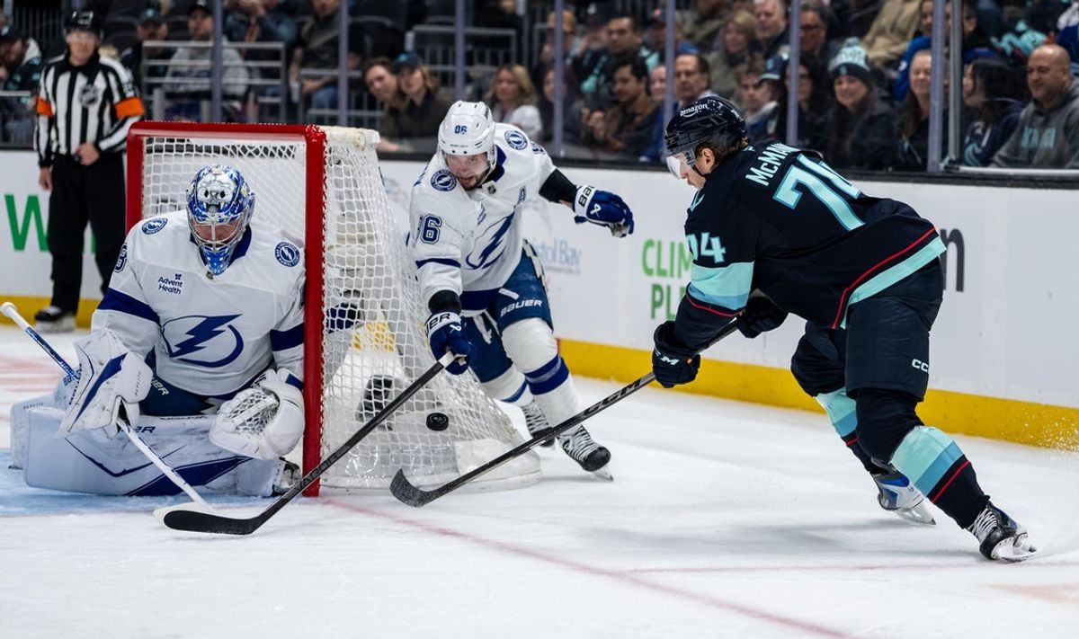 Mar 17, 2026; Seattle, Washington, USA; Seattle Kraken forward Bobby McMann (74) shoots the puck against Seattle Kraken forward Nikita Kucherov (86), center, and goalie Andrei Vasilevskiy (88) during the second period at Climate Pledge Arena. Mandatory Credit: Stephen Brashear-Imagn Images