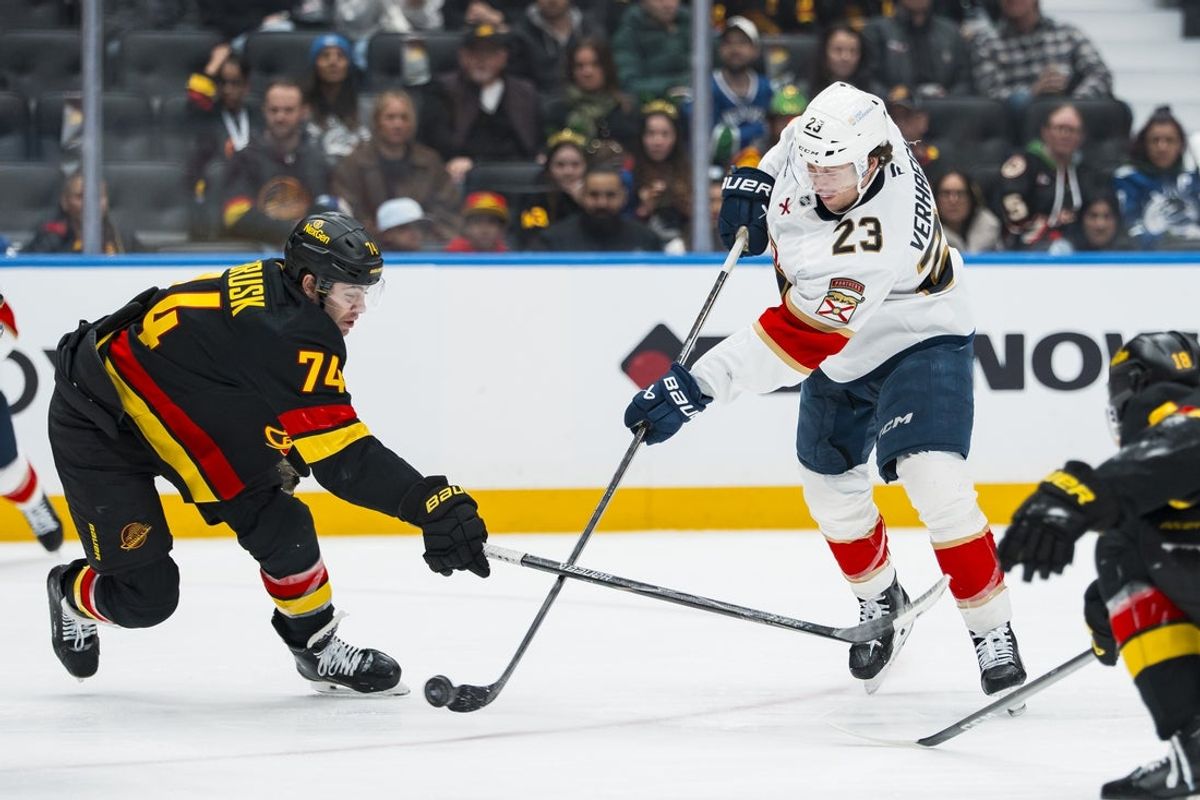 Mar 17, 2026; Vancouver, British Columbia, CAN; Florida Panthers forward Carter Verhaeghe (23) shoots around Vancouver Canucks forward Jake DeBrusk (74) in the third period at Rogers Arena. Mandatory Credit: Bob Frid-Imagn Images