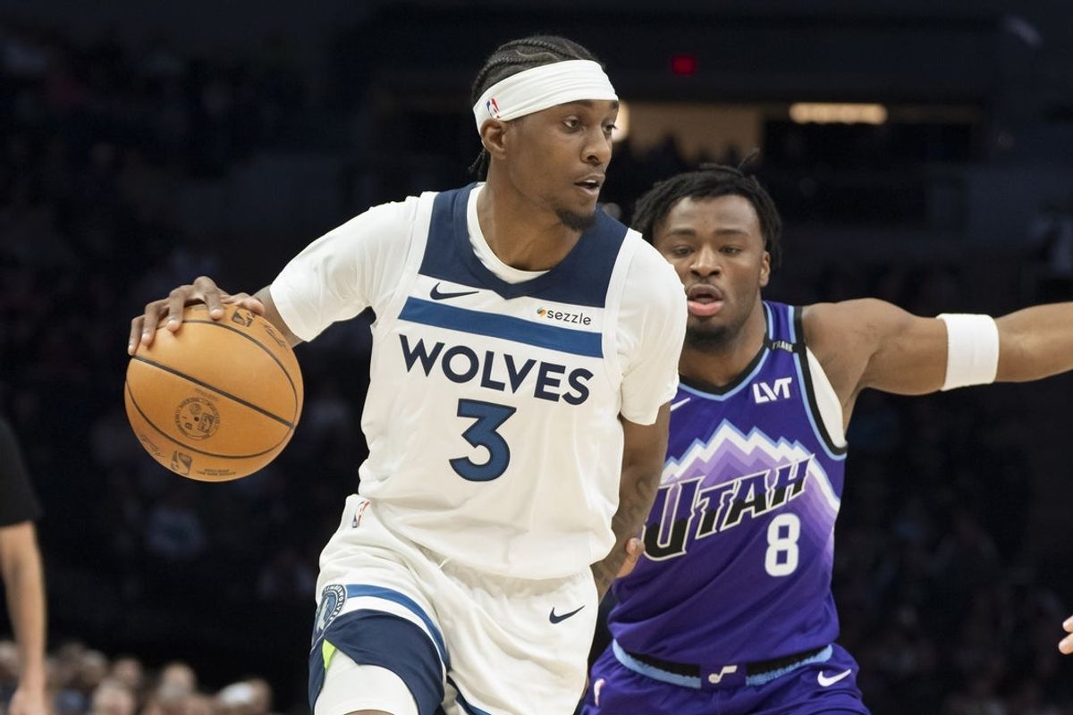 Mar 18, 2026; Minneapolis, Minnesota, USA; Minnesota Timberwolves forward Jaden McDaniels (3) dribbles the ball  past Utah Jazz guard Isaiah Collier (8) in the first half at Target Center. Mandatory Credit: Jesse Johnson-Imagn Images