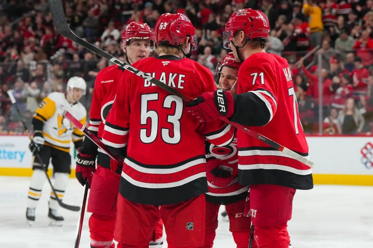 Mar 18, 2026; Raleigh, North Carolina, USA;  Carolina Hurricanes left wing Taylor Hall (71) is congratulated  by center Logan Stankoven (22) right wing Jackson Blake (53) and defenseman Mike Reilly (6) against the Pittsburgh Penguins during the third period at Lenovo Center. Mandatory Credit: James Guillory-Imagn Images