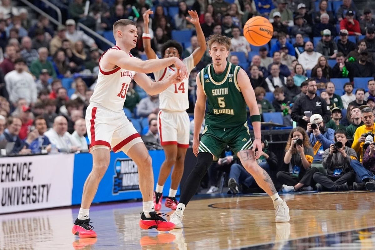 Mar 19, 2026; Buffalo, NY, USA; Louisville Cardinals guard Isaac McKneely (10) passes the ball as South Florida Bulls guard Joseph Pinion (5) defends during the first half during a first round game of the men's 2026 NCAA Tournament at Keybank Center. Mandatory Credit: Gregory Fisher-Imagn Images