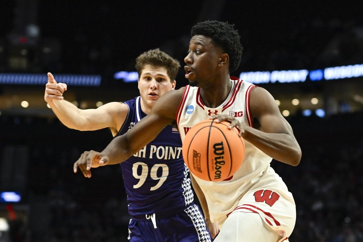 Mar 19, 2026; Portland, OR, USA; Wisconsin Badgers guard John Blackwell (25) drives to the basket against High Point Panthers guard Chase Johnston (99) during the second half of a first round game of the men's 2026 NCAA Tournament at Moda Center. Mandatory Credit: Troy Wayrynen-Imagn Images