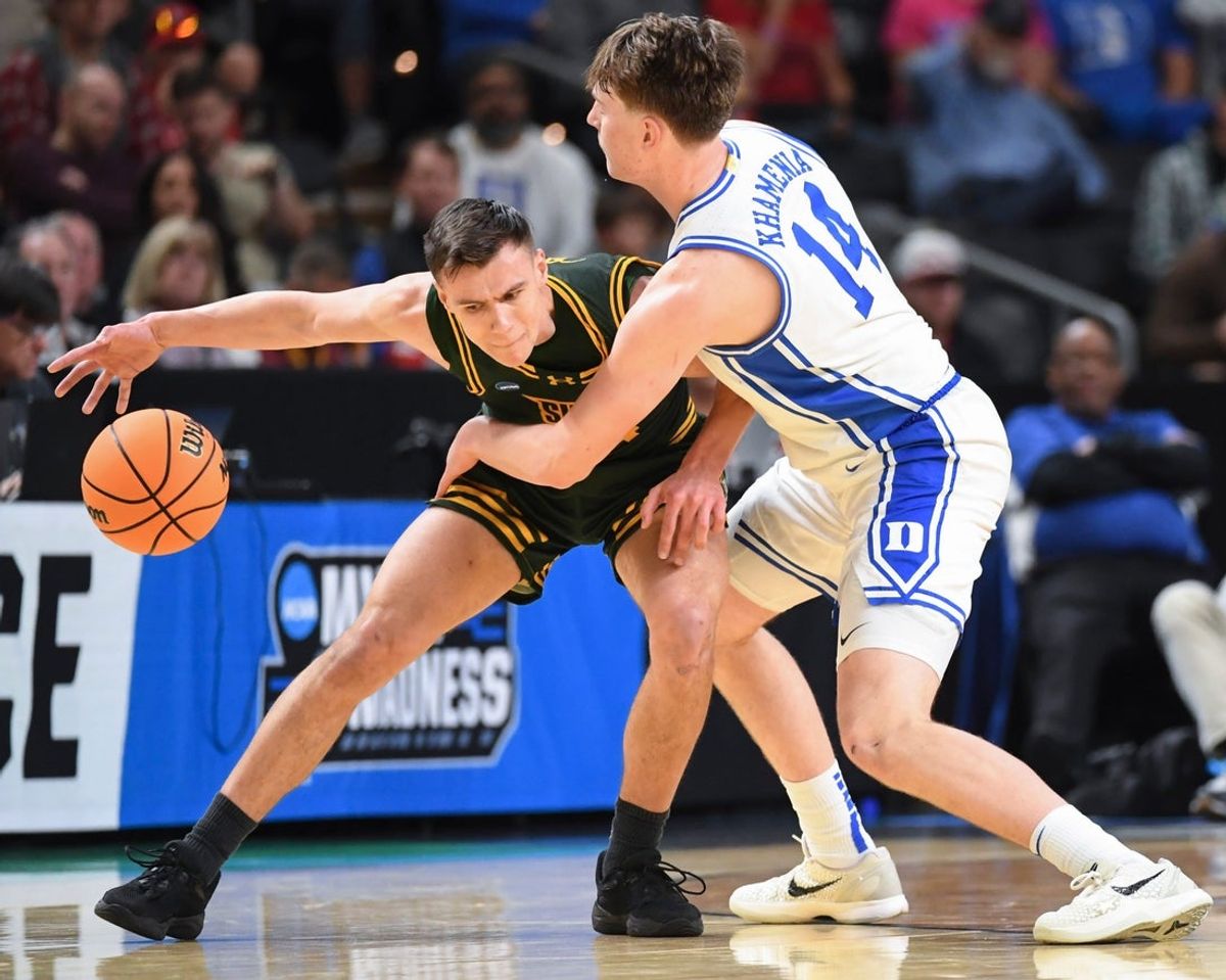 Siena Saints guard Gavin Doty (4) is defended by Duke Blue Devils guard Nikolas Khamenia (14) Thursday, March 19, 2026, during the NCAA Men’s Basketball Tournament first round game at Bon Secours Wellness Arena in Greenville, South Carolina.