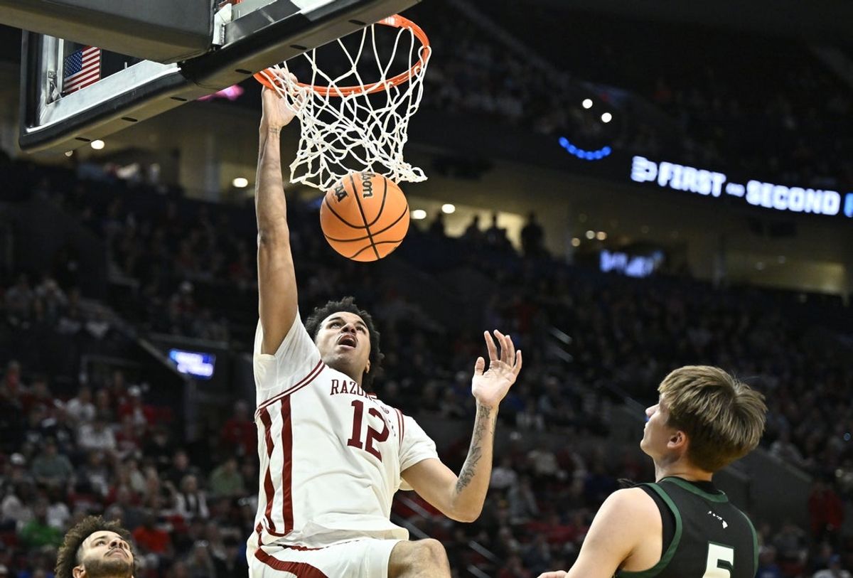 Mar 19, 2026; Portland, OR, USA; Arkansas Razorbacks forward Malique Ewin (12) dunks in the second half against the Hawaii Rainbow Warriors during a first round game of the men's 2026 NCAA Tournament at Moda Center. Mandatory Credit: Craig Strobeck-Imagn Images