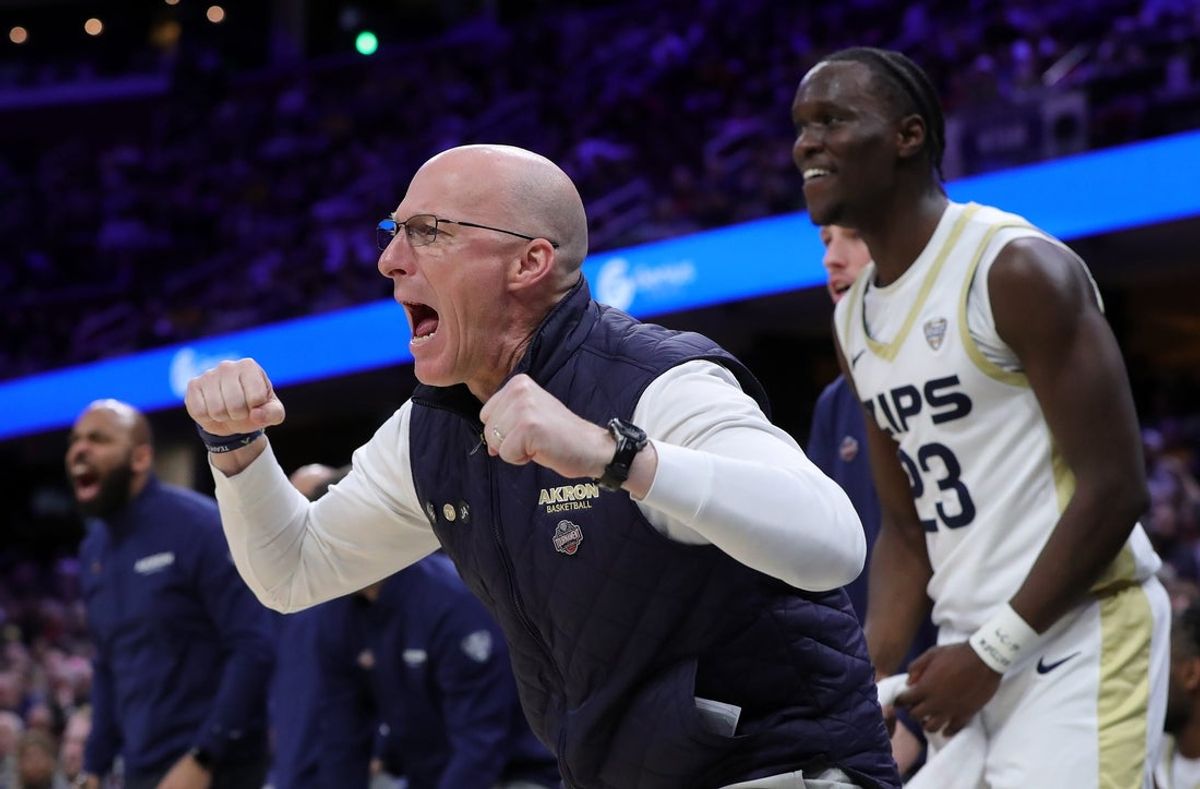 Akron Zips coach John Groce celebrates after a foul call during a Mid-American Conference Tournament semifinal against Kent State on March 13, 2026, in Cleveland.