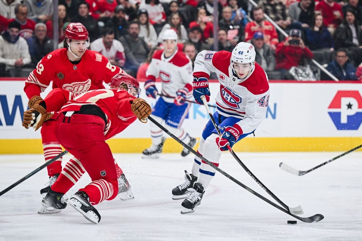 Mar 19, 2026; Detroit, Michigan, USA; Montreal Canadiens defenseman Lane Hutson (48) shoots as Detroit Red Wings defenseman Simon Edvinsson (77) defends during the first period at Little Caesars Arena. Mandatory Credit: Tim Fuller-Imagn Images