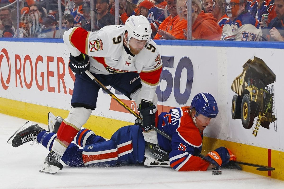 Mar 19, 2026; Edmonton, Alberta, CAN; Florida Panthers forward Sam Bennett (9) gets the puck away from Edmonton Oilers defensemen Connor Murphy (5) during the second period at Rogers Place. Mandatory Credit: Perry Nelson-Imagn Images