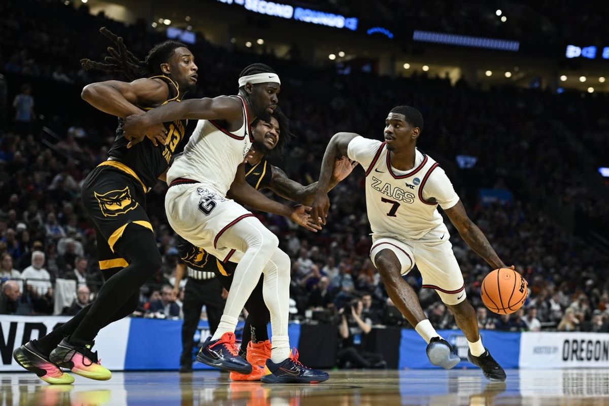 Mar 19, 2026; Portland, OR, USA; Gonzaga Bulldogs guard Tyon Grant-Foster (7) drives to the basket against Kennesaw State Owls forward Braedan Lue (13) during the first half of a first round game of the men's 2026 NCAA Tournament at Moda Center. Mandatory Credit: Troy Wayrynen-Imagn Images