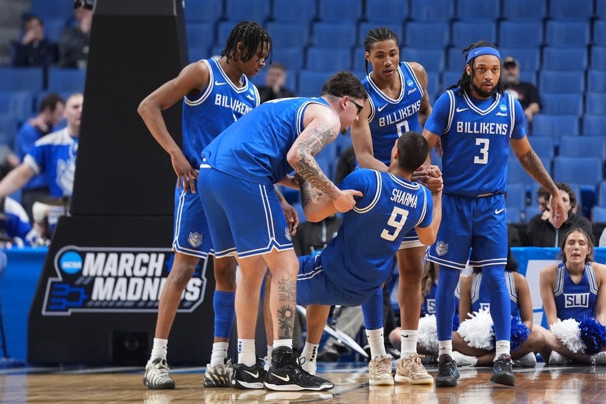 Mar 19, 2026; Buffalo, NY, USA; Saint Louis Billikens forward Ishan Sharma (9) is helped to his feet by center Robbie Avila (21) and guard Trey Green (3) after getting fouled by Georgia Bulldogs guard Blue Cain (not pictured) during the second half of a first round game of the men's 2026 NCAA Tournament at Keybank Center. Mandatory Credit: Gregory Fisher-Imagn Images