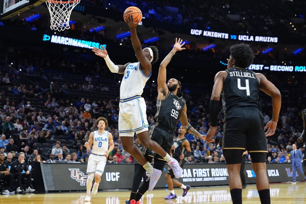 Mar 20, 2026; Philadelphia, PA, USA; UCLA Bruins forward Eric Dailey Jr. (3) shoots the ball past UCF Knights forward Jordan Burks (99) in the first half during a first round game of the men's 2026 NCAA Tournament at Xfinity Mobile Arena. Mandatory Credit: Kyle Ross-Imagn Images