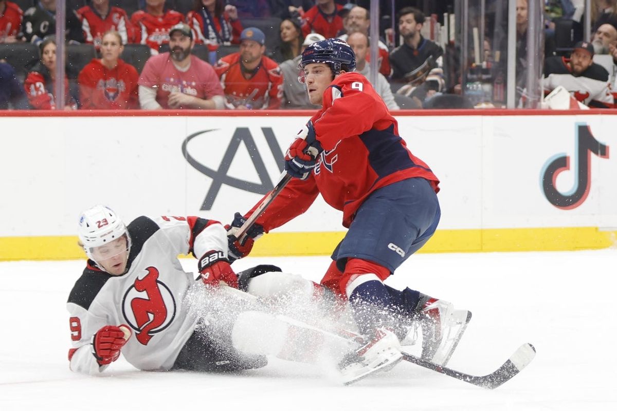Mar 20, 2026; Washington, District of Columbia, USA; Washington Capitals right wing Ryan Leonard (9) trips over New Jersey Devils right wing Lenni Hameenaho (29) after scoring a goal during the first period at Capital One Arena. Mandatory Credit: Amber Searls-Imagn Images