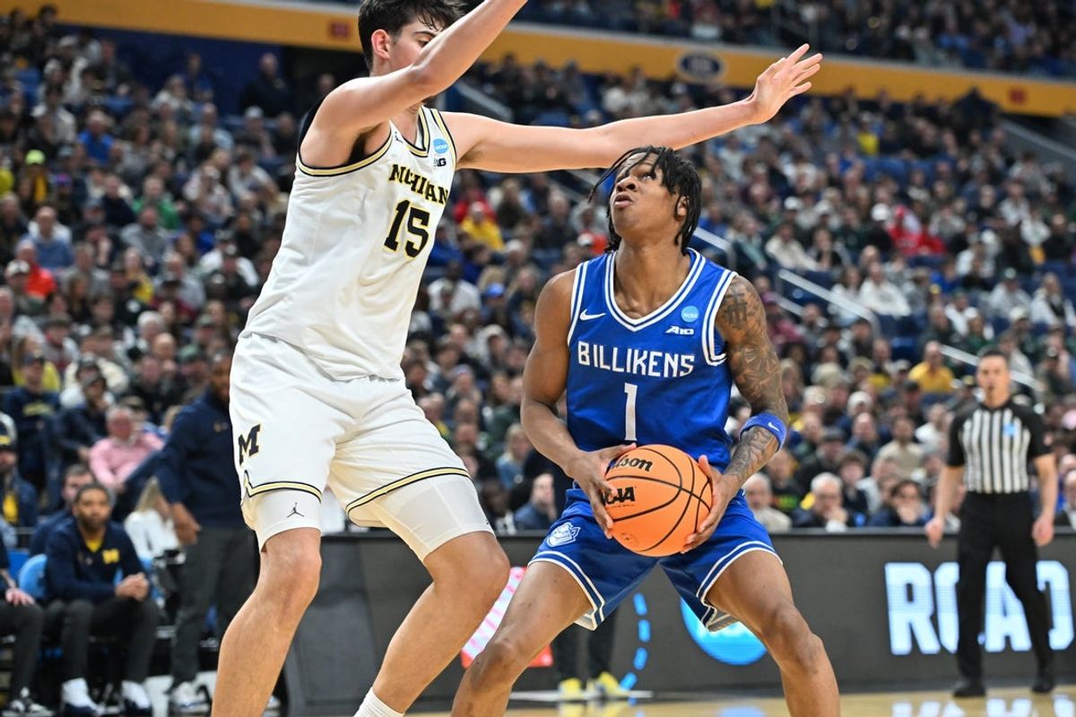 Mar 21, 2026; Buffalo, NY, USA; Saint Louis Billikens guard Quentin Jones (1) drives the ball while defended by Michigan Wolverines center Aday Mara (15) in the first half during a second round game of the men's 2026 NCAA Tournament at Keybank Center. Mandatory Credit: Mark Konezny-Imagn Images