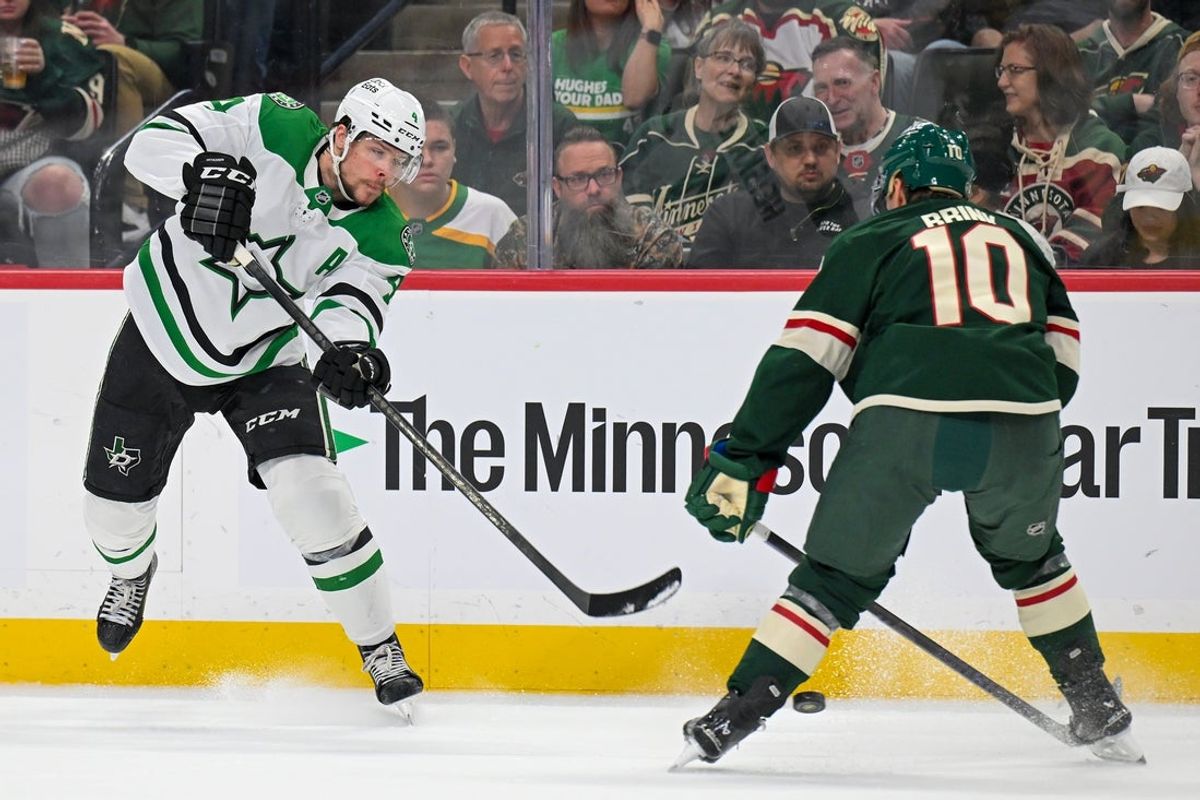 Mar 21, 2026; Saint Paul, Minnesota, USA;  Dallas Stars defensemen Miro Heiskanen (4) shoots the puck between the legs of Minnesota Wild forward Bobby Brink (10) during the first period at Grand Casino Arena. Mandatory Credit: Nick Wosika-Imagn Images