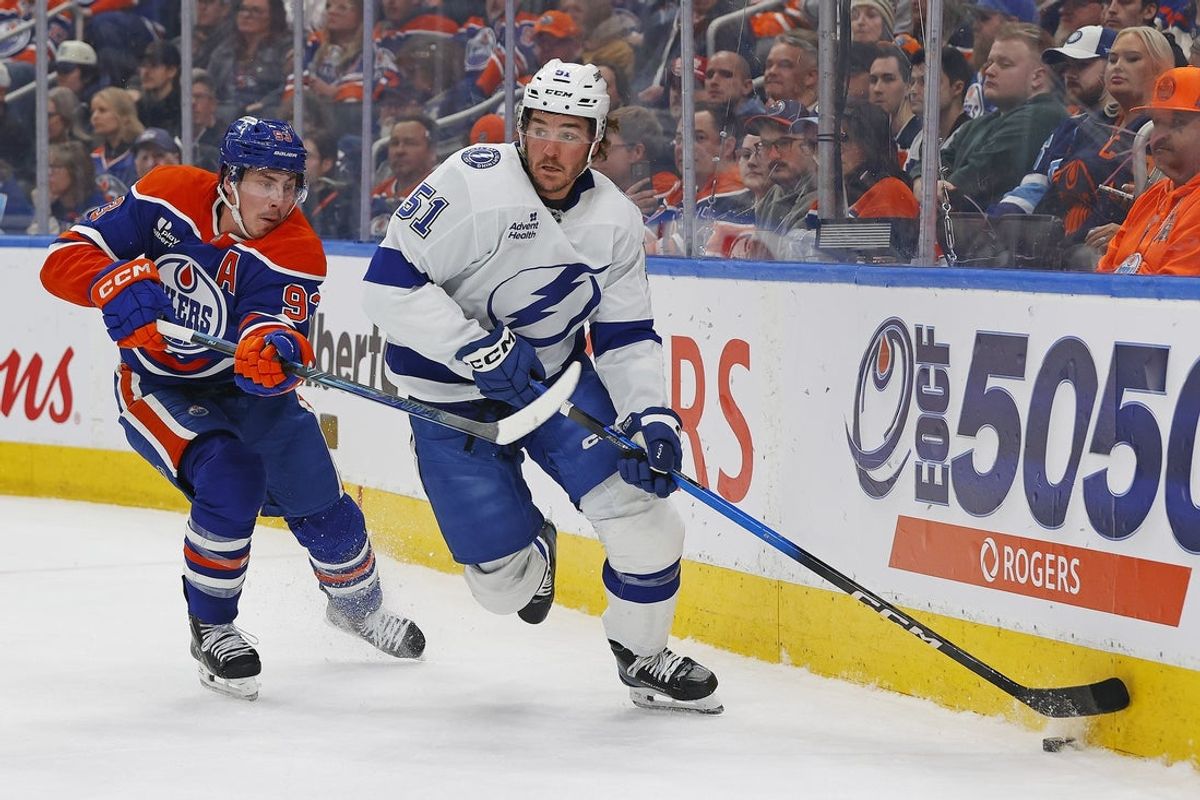 Mar 21, 2026; Edmonton, Alberta, CAN; Tampa Bay Lightning defensemen Charle-Edouard D'Astous (51) looks to clear the puck in front of Edmonton Oilers forward Ryan Nugent-Hopkins (93) during the first period at Rogers Place. Mandatory Credit: Perry Nelson-Imagn Images