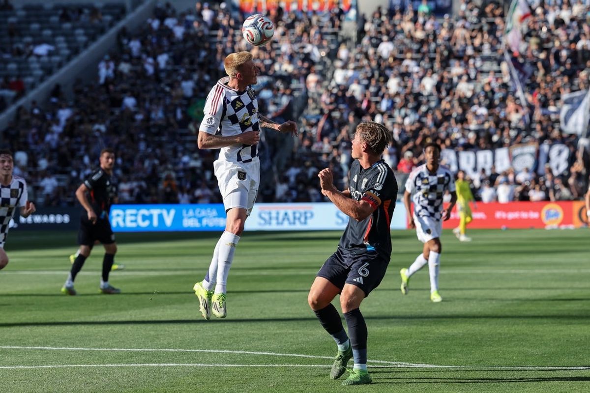 Mar 22, 2026; San Diego, California, USA; Real Salt Lake defender Justen Glad (15) heads the ball away from San Diego FC defender Jeppe Tverskov (6) during the first half at Snapdragon Stadium. Mandatory Credit: Chadd Cady-Imagn Images