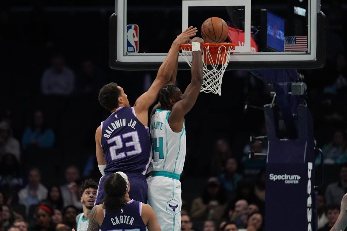 Mar 24, 2026; Charlotte, North Carolina, USA; Charlotte Hornets forward Moussa Diabaté (14) makes a slam dunk guarded by Sacramento Kings forward Patrick Baldwin Jr. (23) during the first quarter at Spectrum Center. Mandatory Credit: Jim Dedmon-Imagn Images
