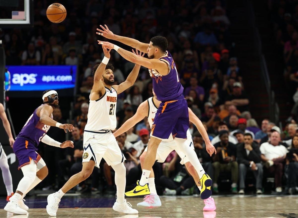 Mar 24, 2026; Phoenix, Arizona, USA; Phoenix Suns guard Devin Booker (1) passes the ball against Denver Nuggets guard Jamal Murray (27) in the first half at Mortgage Matchup Center. Mandatory Credit: Mark J. Rebilas-Imagn Images