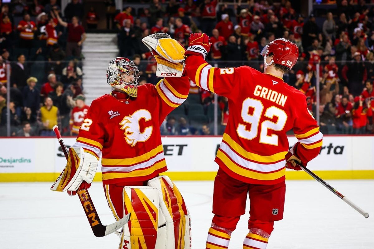 Mar 24, 2026; Calgary, Alberta, CAN; Calgary Flames goaltender Dustin Wolf (32) celebrates win with right wing Matvei Gridin (92) after defeating Los Angeles Kings during the shootout period at Scotiabank Saddledome. Mandatory Credit: Sergei Belski-Imagn Images