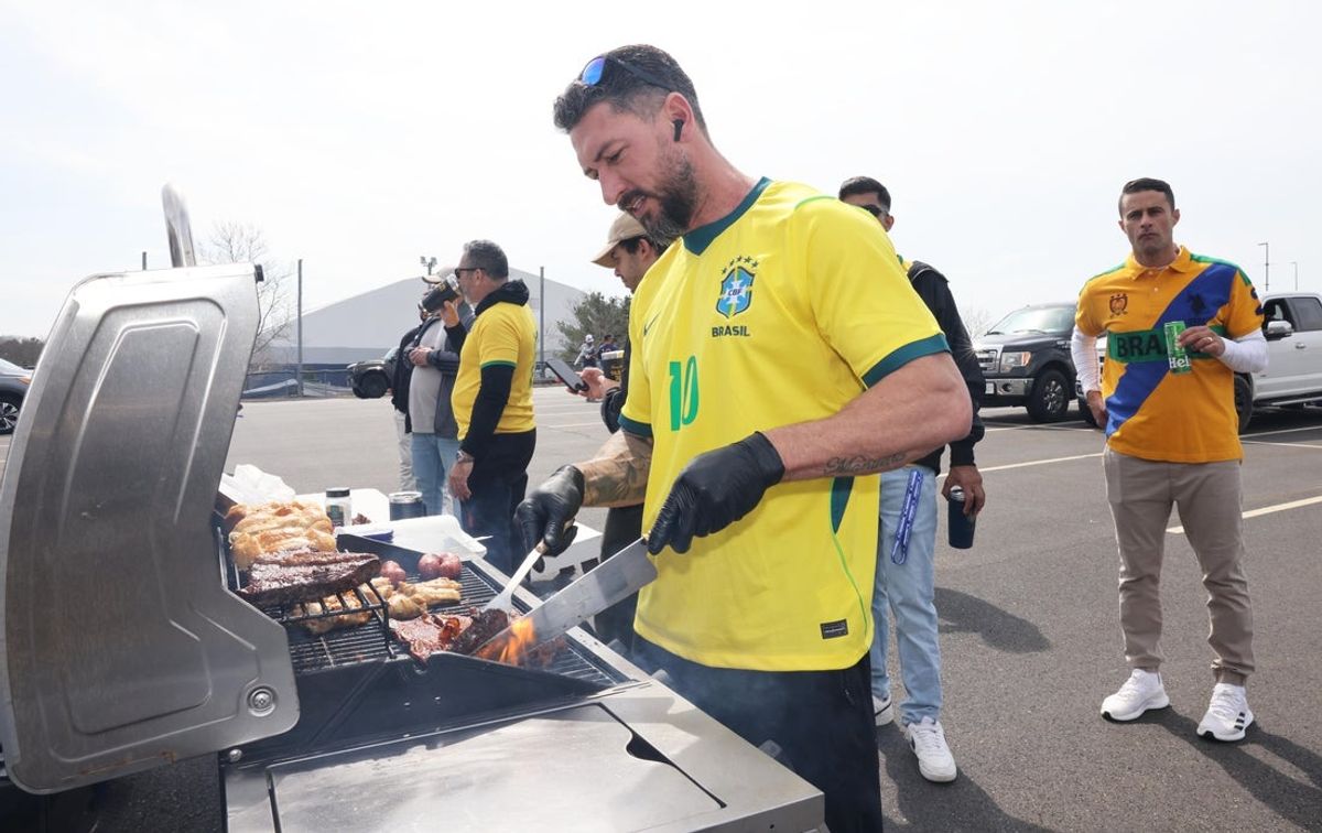 Wenderson Bernardes cooks during a tailgate party in the parking lot at Gillette Stadium, Foxboro, MA, for the FIFA International Friendly between Brazil and France on Thursday, March 26, 2026.