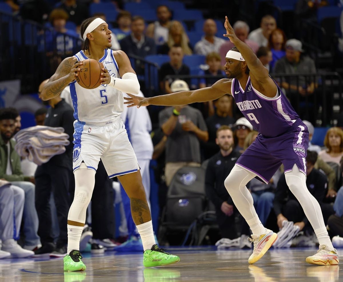 Mar 26, 2026; Orlando, Florida, USA;  Orlando Magic forward Paolo Banchero (5) looks to pass as Sacramento Kings center Precious Achiuwa (9) defends in the first half at Kia Center. Mandatory Credit: Russell Lansford-Imagn Images