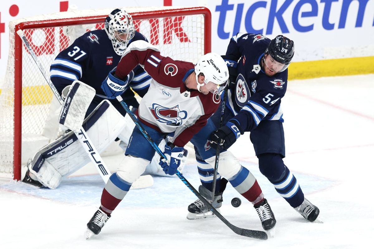 Mar 26, 2026; Winnipeg, Manitoba, CAN; Colorado Avalanche center Brock Nelson (11) and Winnipeg Jets defenseman Dylan Samberg (54) fight for the puck in front of Winnipeg Jets goaltender Connor Hellebuyck (37) in the second period at Canada Life Centre. Mandatory Credit: James Carey Lauder-Imagn Images
