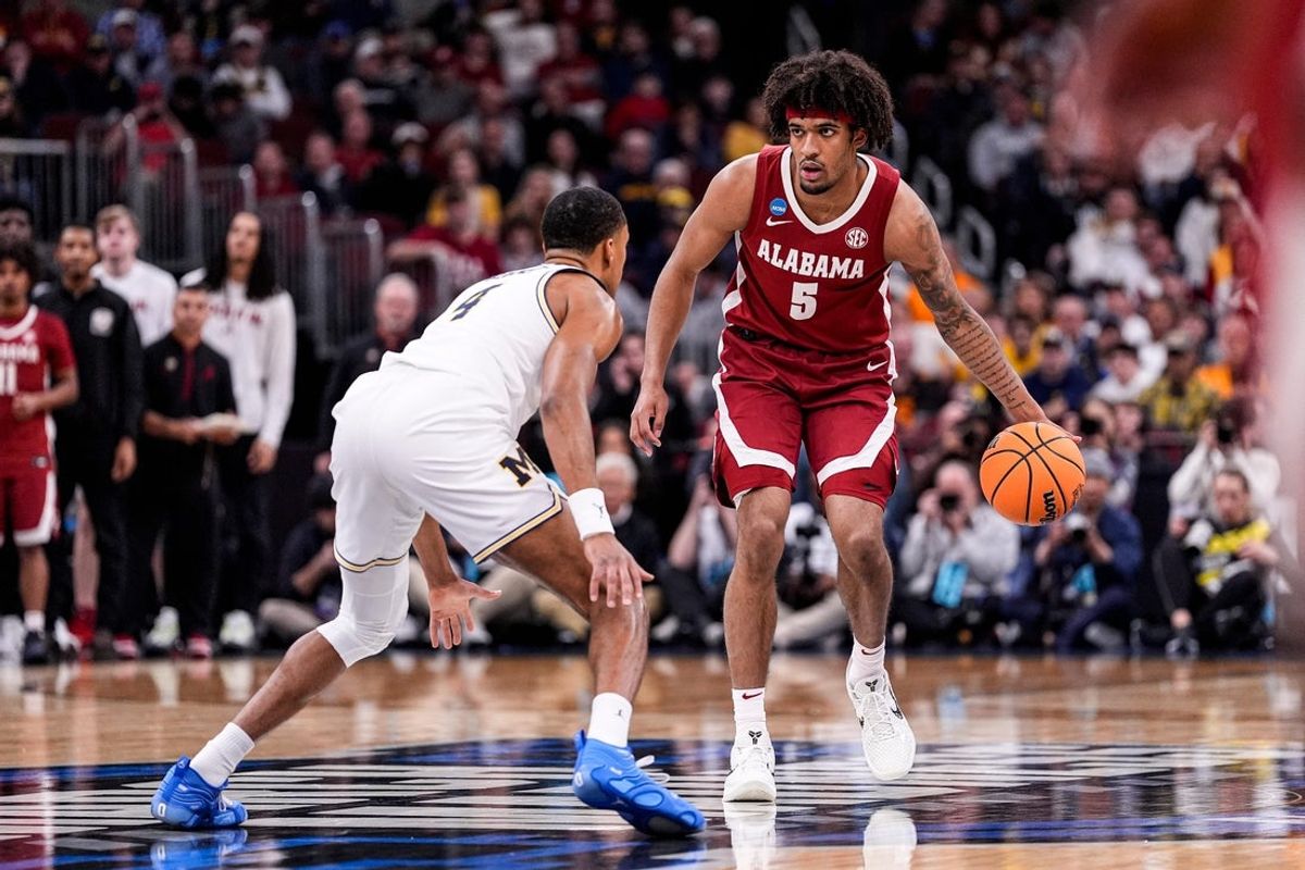 Alabama forward Amari Allen (5) dribbles against Michigan guard Nimari Burnett (4) during the first half of NCAA Tournament Sweet 16 round at United Center in Chicago on Friday, March 27, 2026.