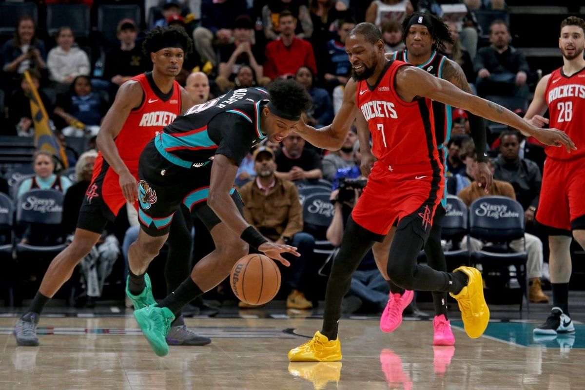 Mar 27, 2026; Memphis, Tennessee, USA; Memphis Grizzlies forward Olivier-Maxence Prosper (18) and Houston Rockets forward Kevin Durant (7) battle for a loose ball during the second quarter at FedExForum. Mandatory Credit: Petre Thomas-Imagn Images