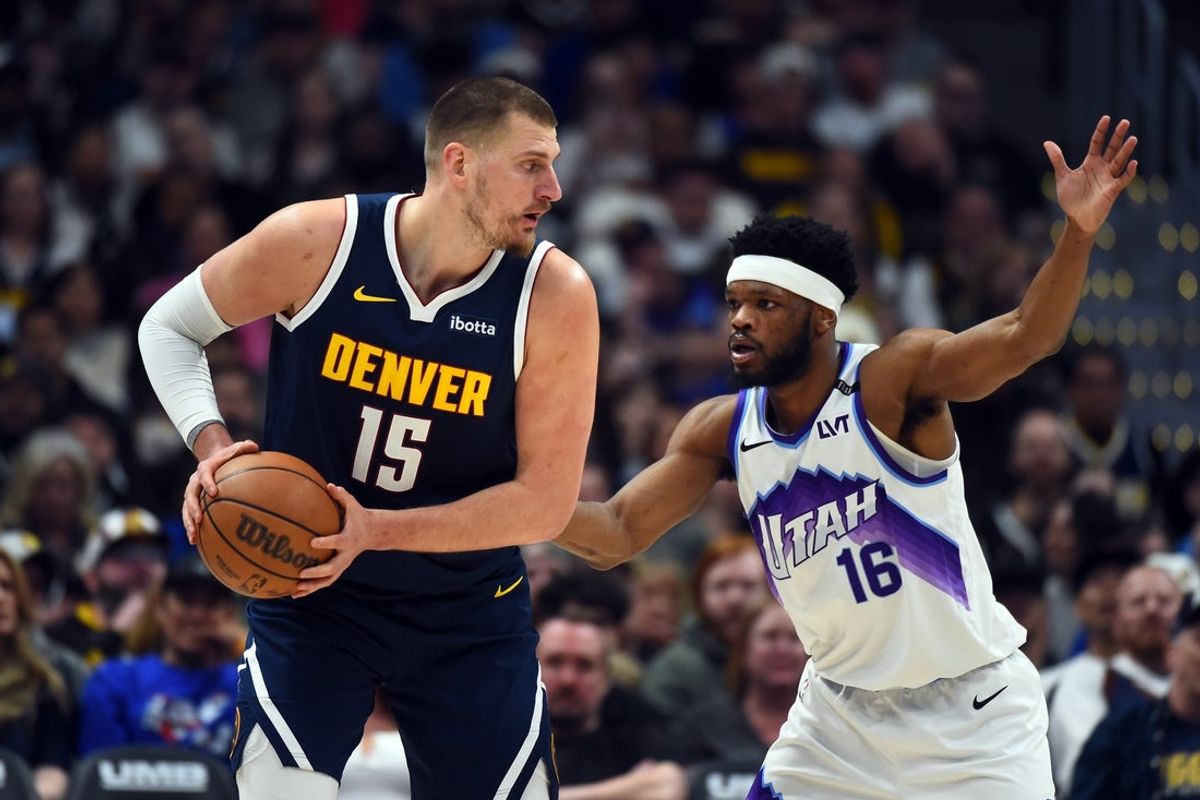 Mar 27, 2026; Denver, Colorado, USA; Denver Nuggets center Nikola Jokic (15) looks to pass the ball as he is defended by Utah Jazz guard Elijah Harkless (16) during the first half at Ball Arena. Mandatory Credit: Christopher Hanewinckel-Imagn Images