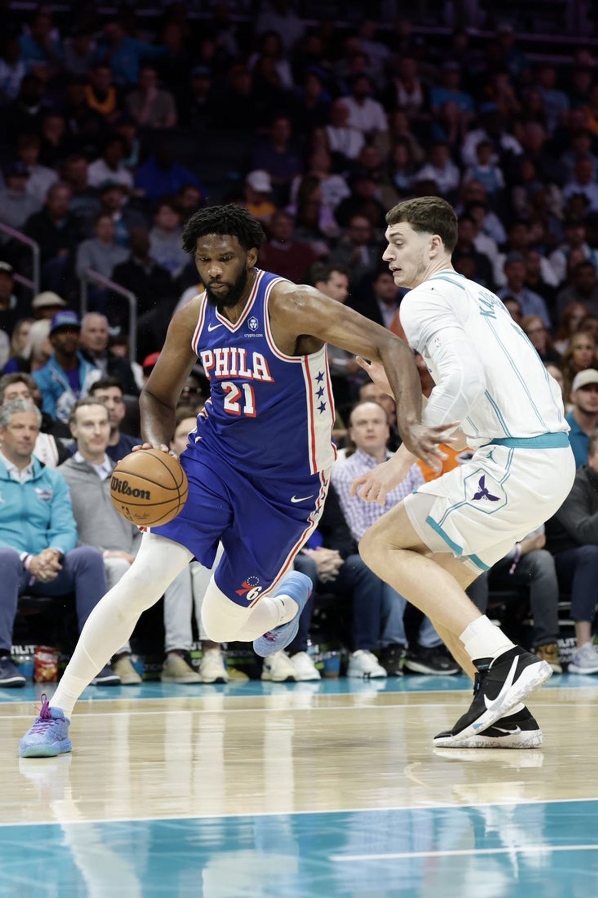 Mar 28, 2026; Charlotte, North Carolina, USA; Philadelphia 76ers forward Joel Embiid (21) drives past Charlotte Hornets center Ryan Kalkbrenner (11) during the first quarter at Spectrum Center. Mandatory Credit: Brian Westerholt-Imagn Images