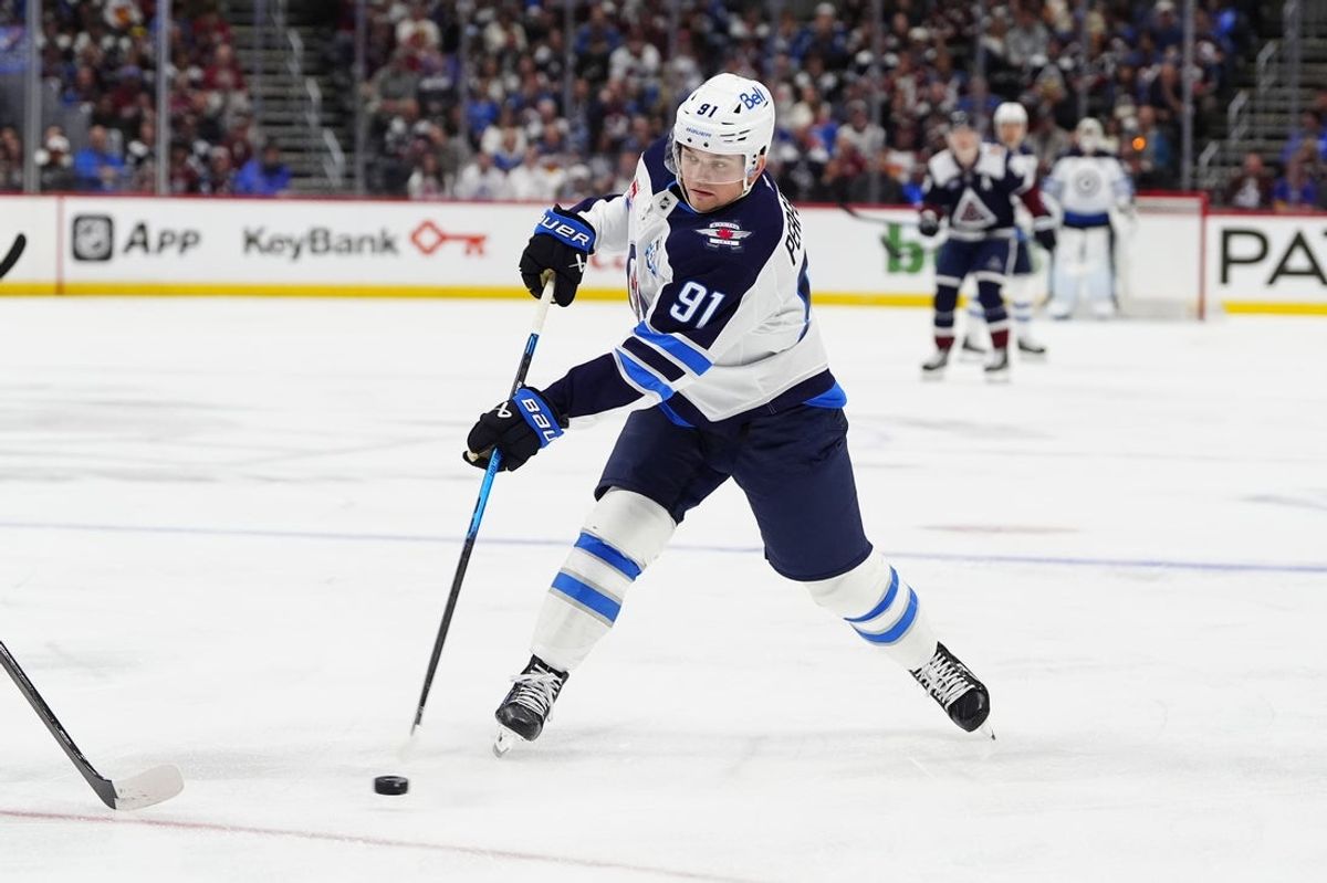 Mar 28, 2026; Denver, Colorado, USA; Winnipeg Jets center Cole Perfetti (91) shoots the puck in the first period against the Colorado Avalanche at Ball Arena. Mandatory Credit: Ron Chenoy-Imagn Images