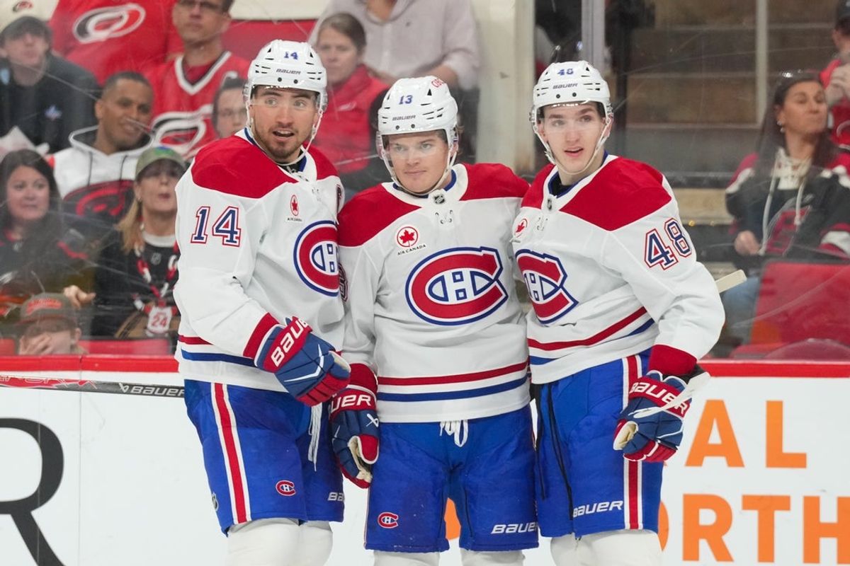 Mar 29, 2026; Raleigh, North Carolina, USA;  Montreal Canadiens center Nick Suzuki (14) is congratulated by defenseman Lane Hutson (48) and right wing Cole Caufield (13) after his goal against the Carolina Hurricanes during the second period at Lenovo Center. Mandatory Credit: James Guillory-Imagn Images
