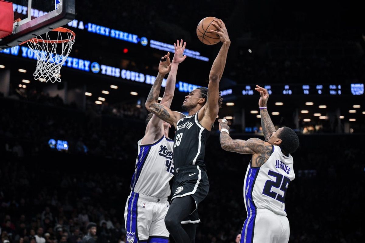Mar 29, 2026; Brooklyn, New York, USA; Brooklyn Nets center Nic Claxton (33) drives to the basket while defended by Sacramento Kings center Maxime Raynaud (42) and guard/forward Daeqwon Plowden (29) during the first half at Barclays Center. Mandatory Credit: John Jones-Imagn Images