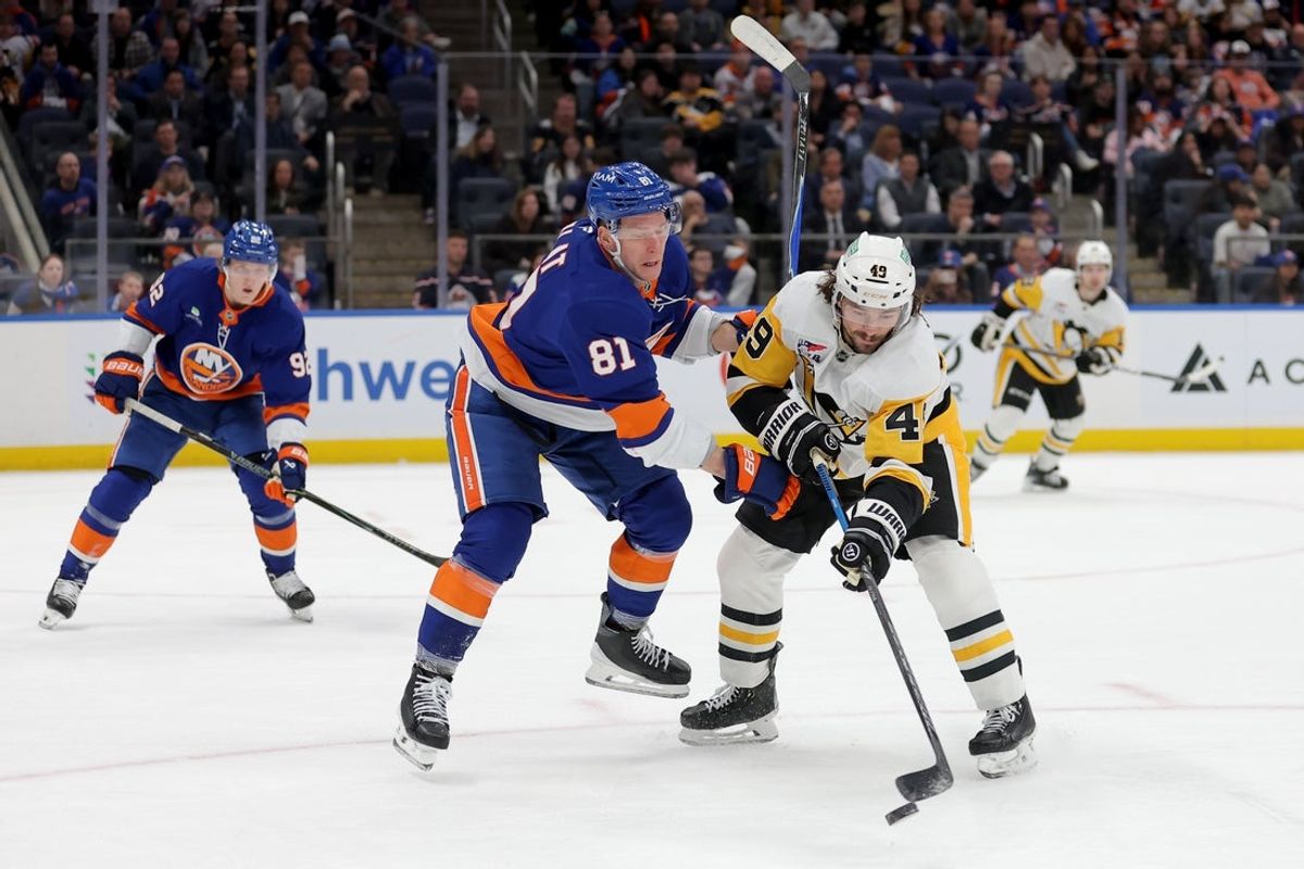 Mar 30, 2026; Elmont, New York, USA; Pittsburgh Penguins defenseman Samuel Girard (49) plays the puck against New York Islanders left wing Ondrej Palat (81) during the second period at UBS Arena. Mandatory Credit: Brad Penner-Imagn Images