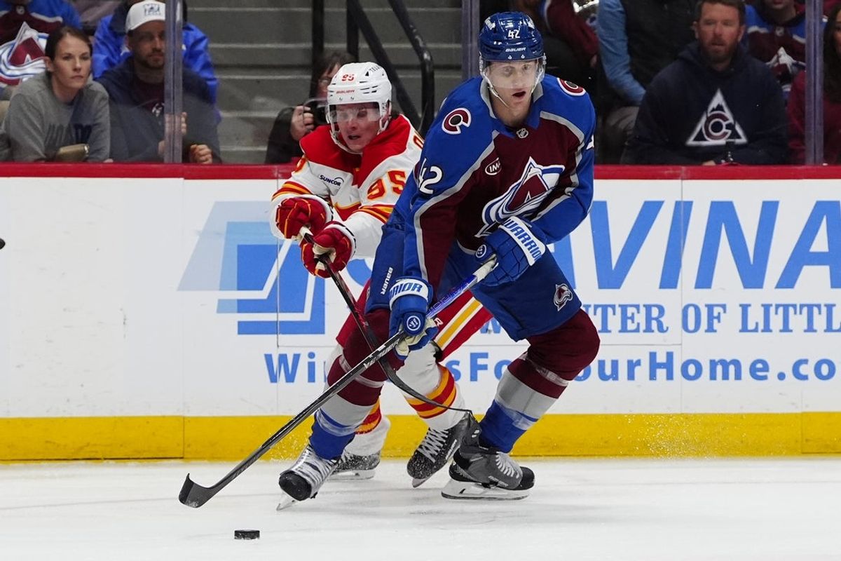 Mar 30, 2026; Denver, Colorado, USA; Calgary Flames left wing Victor Olofsson (95) and Colorado Avalanche defenseman Josh Manson (42) battle for the puck in the first period at Ball Arena. Mandatory Credit: Ron Chenoy-Imagn Images