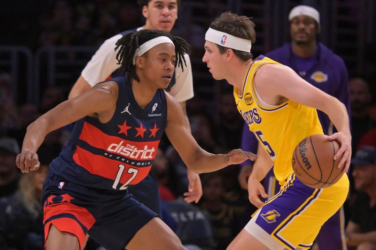 Mar 30, 2026; Los Angeles, California, USA; Washington Wizards guard Tre Johnson (12) defends Los Angeles Lakers guard Austin Reaves (15) during the first half at Crypto.com Arena. Mandatory Credit: Jayne Kamin-Oncea-Imagn Images