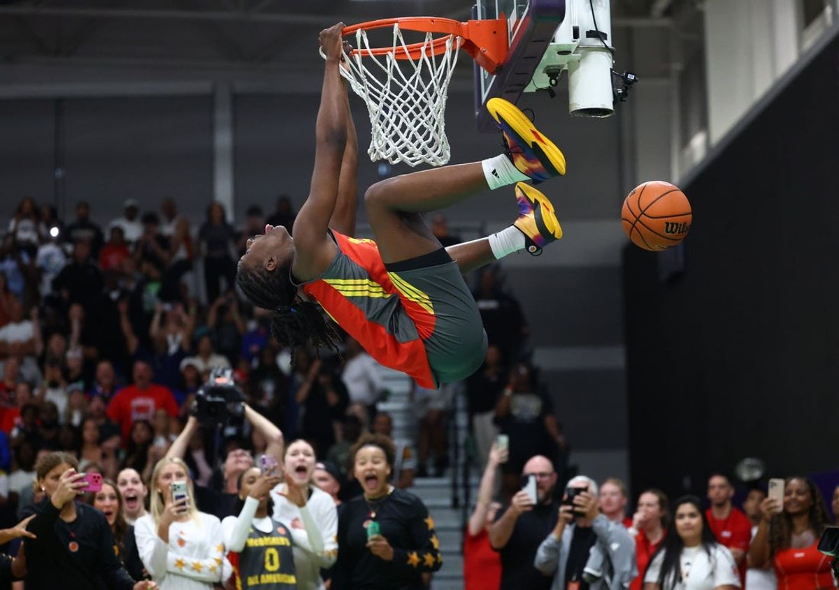 Mar 30, 2026; Goodyear, AZ, USA; Oliviyah Edwards hangs upside down from the rim as she celebrates after dunking the ball during the McDonalds All American Jam Fest at Millennium High School. Mandatory Credit: Mark J. Rebilas-Imagn Images