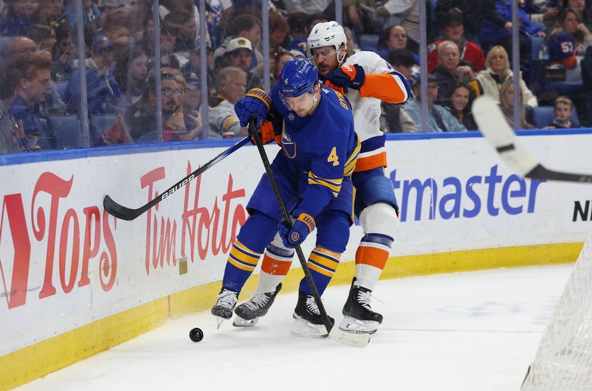 Mar 31, 2026; Buffalo, New York, USA;  Buffalo Sabres defenseman Bowen Byram (4) tries to control the puck as New York Islanders defenseman Ryan Pulock (6) defends during the first period at KeyBank Center. Mandatory Credit: Timothy T. Ludwig-Imagn Images