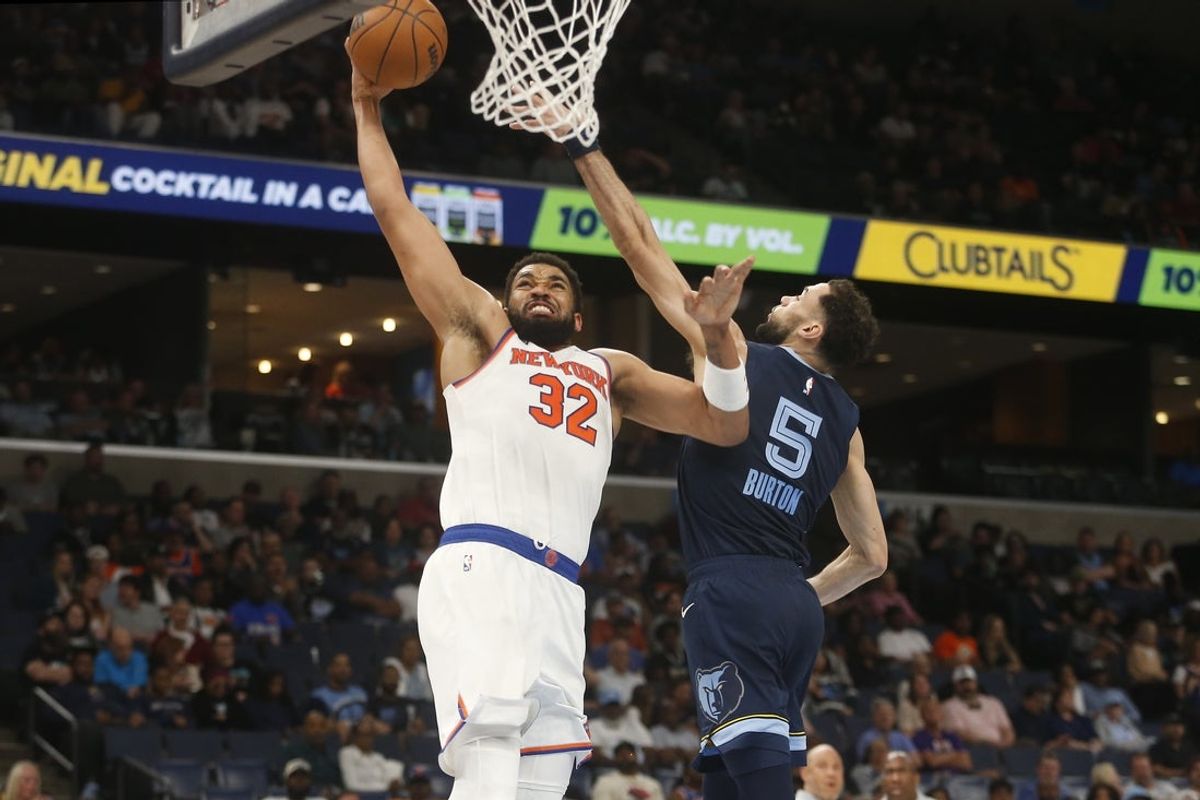 Apr 1, 2026; Memphis, Tennessee, USA; New York Knicks center Karl-Anthony Towns (32) drives to the basket as Memphis Grizzlies forward Tyler Burton (5) defends during the second quarter at FedExForum. Mandatory Credit: Petre Thomas-Imagn Images