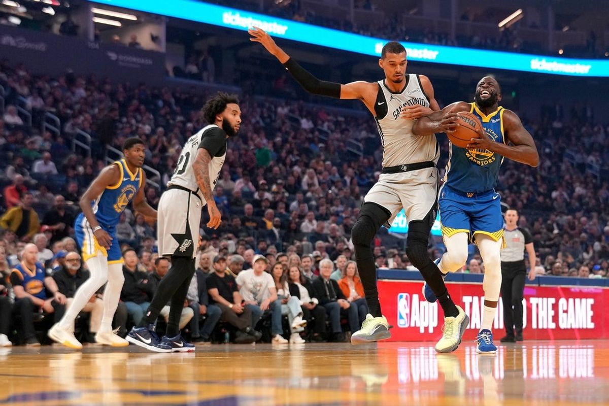 Apr 1, 2026; San Francisco, California, USA; Golden State Warriors forward Draymond Green (23) drives to the hoop next to San Antonio Spurs center Victor Wembanyama (1) in the first quarter at the Chase Center. Mandatory Credit: Cary Edmondson-Imagn Images