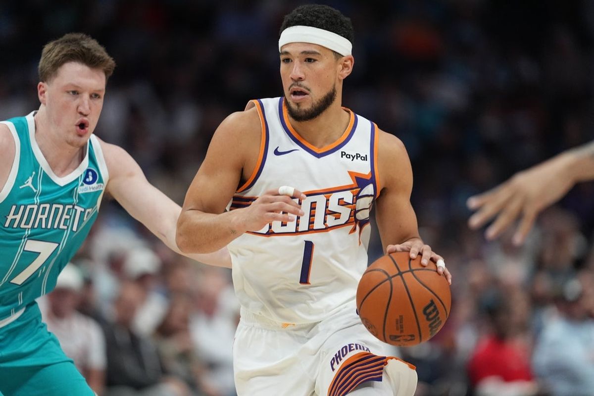 Apr 2, 2026; Charlotte, North Carolina, USA; Phoenix Suns guard Devin Booker (1) handles the ball defended by Charlotte Hornets guard/forward Kon Knueppel (7) during the first quarter at Spectrum Center. Mandatory Credit: Jim Dedmon-Imagn Images