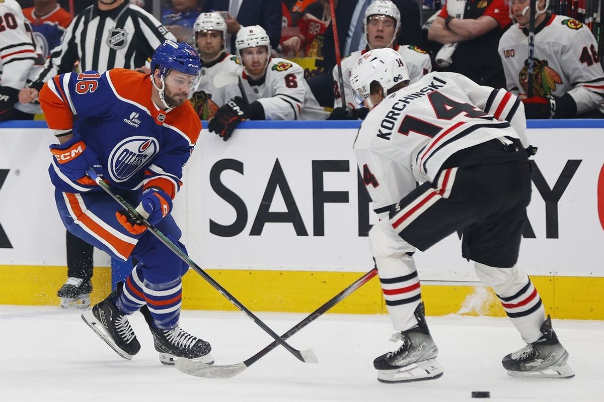 Apr 2, 2026; Edmonton, Alberta, CAN; Edmonton Oilers forward Jason Dickenson  (16) tries to play the puck past Chicago Blackhawks defensemen Kevin Korchinski (14) during the first period at Rogers Place. Mandatory Credit: Perry Nelson-Imagn Images