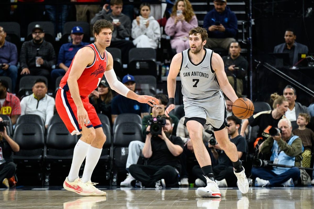 Apr 2, 2026; Inglewood, California, USA; San Antonio Spurs center Luke Kornet (7) controls the ball while under pressure from Los Angeles Clippers center Brook Lopez (11) during the first half at Intuit Dome. Mandatory Credit: William Liang-Imagn Images