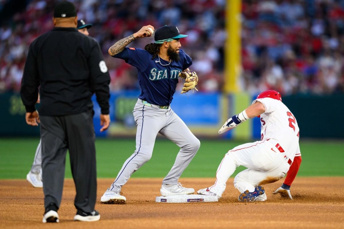 Apr 3, 2026; Anaheim, California, USA; Seattle Mariners shortstop J.P. Crawford (3) looks to throw to first base after forcing out Los Angeles Angels center fielder Mike Trout (27) during the first inning at Angel Stadium. Mandatory Credit: William Liang-Imagn Images