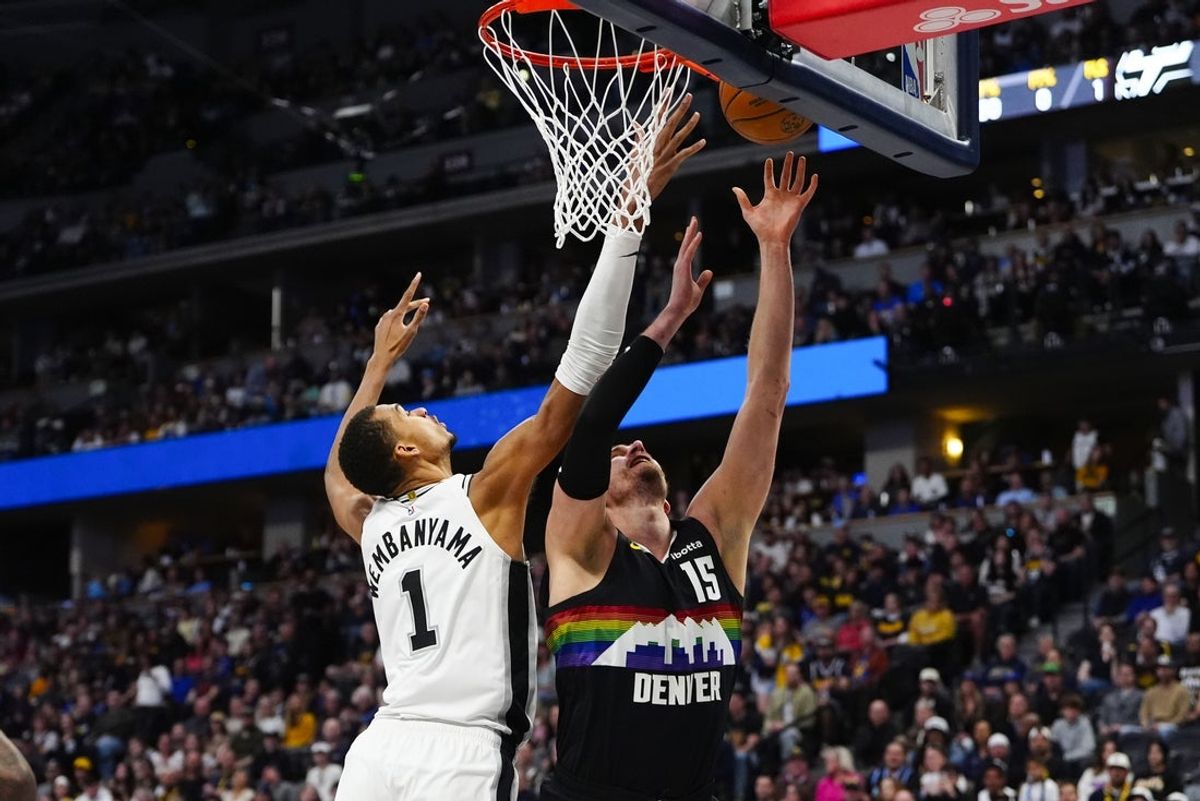 Apr 4, 2026; Denver, Colorado, USA; San Antonio Spurs forward Victor Wembanyama (1) rebounds against Denver Nuggets center Nikola Jokic (15) in the first quarter at Ball Arena. Mandatory Credit: Ron Chenoy-Imagn Images