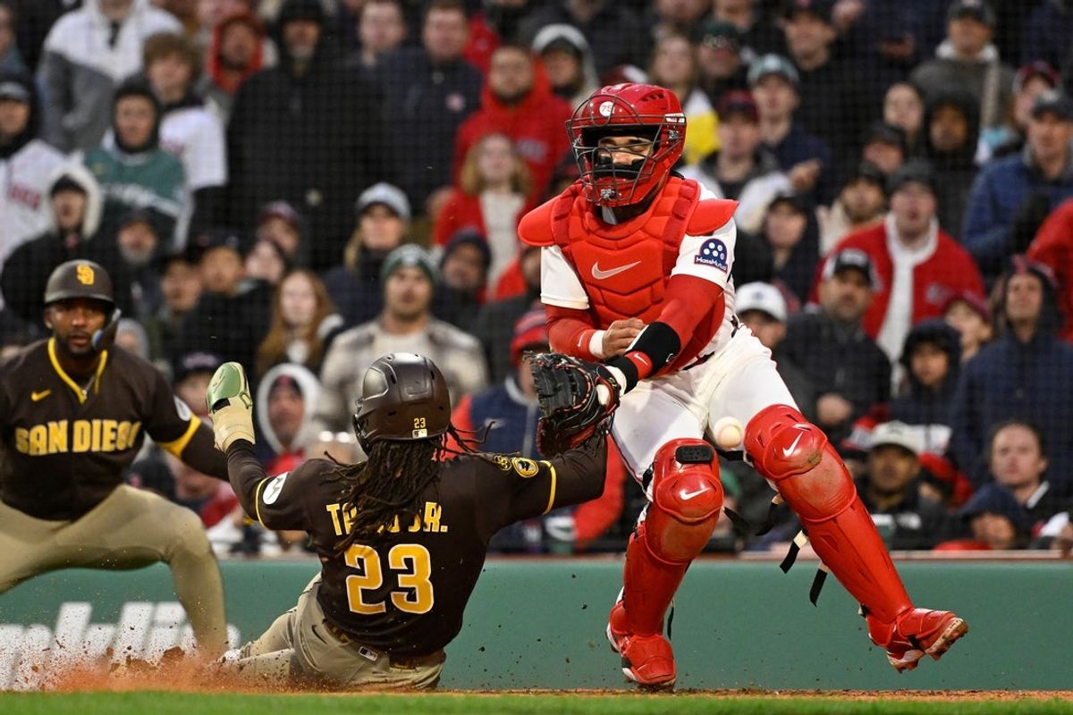 Apr 4, 2026; Foxborough, Massachusetts, USA; San Diego Padres right fielder Fernando Tatis Jr. (23) scores a run against Boston Red Sox catcher Carlos Narvaez (75) during the ninth inning at Fenway Park. Mandatory Credit: Eric Canha-Imagn Images