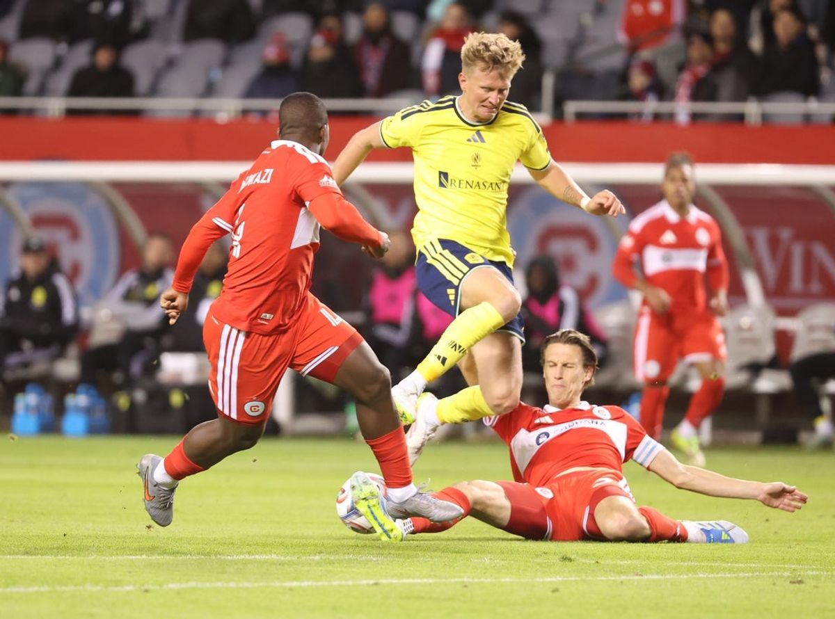 Apr 4, 2026; Chicago, Illinois, USA; Chicago Fire FC defender Jack Elliott (3), defender Mbekezeli Mbokazi (4) and Nashville SC forward Sam Surridge (9) battle for control of the ball during the second half at Soldier Field. Mandatory Credit: Talia Sprague-Imagn Images