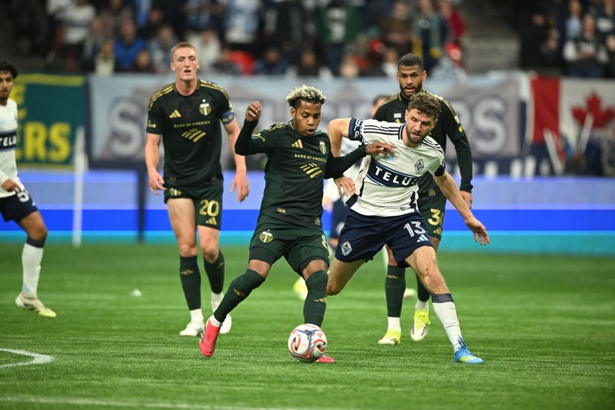 Apr 4, 2026; Vancouver, British Columbia, CAN;  Portland Timbers midfielder Joao Ortiz (80) mbattles for the ball against Vancouver Whitecaps FC midfielder Thomas Muller (13) during the first half at BC Place. Mandatory Credit: Anne-Marie Sorvin-Imagn Images