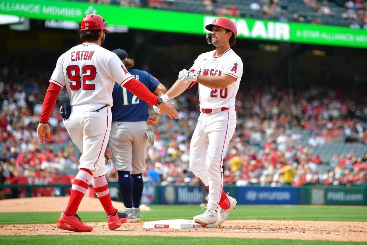 Apr 5, 2026; Anaheim, California, USA; Los Angeles Angels second baseman Adam Frazier (20) is greeted by first base/outfield coach Adam Eaton (92) after hitting an RBI single against the Seattle Mariners during the fifth inning at Angel Stadium. Mandatory Credit: Gary A. Vasquez-Imagn Images