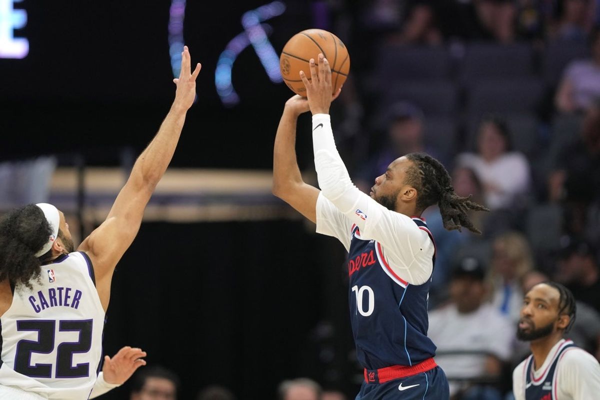 Apr 5, 2026; Sacramento, California, USA; LA Clippers guard Darius Garland (center right) shoots against Sacramento Kings guard Devin Carter (22) during the second quarter at Golden 1 Center. Mandatory Credit: Darren Yamashita-Imagn Images